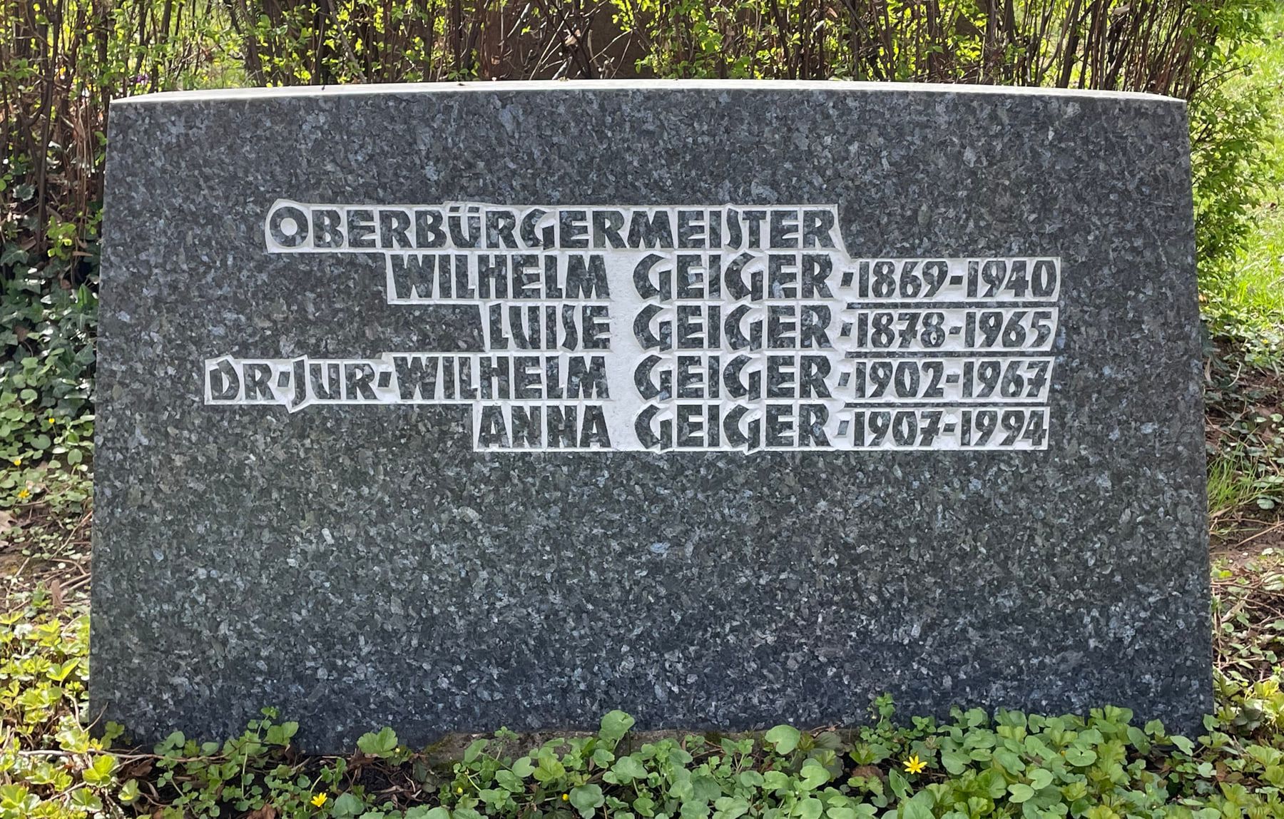 Dunkles Granitgrabmal der Familie Geiger mit erhaben gesetzter Inschrift auf Friedhof Feuerbach